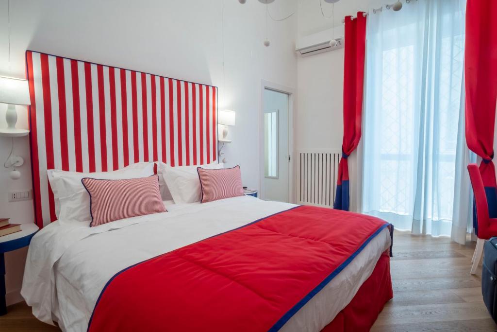 a bedroom with a red and white bed with pink pillows at Sea View Luxury Apartment in Castellammare di Stabia