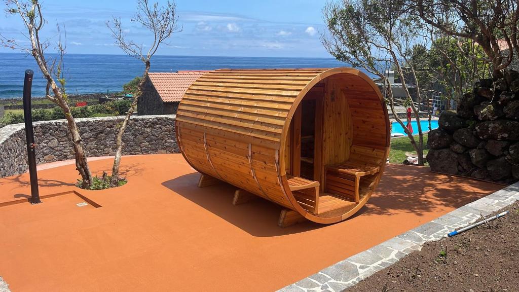 a small wooden boat sitting on top of a patio at Kuanza Nature Experience, Fajã do Belo in Fajã da Caldeira de Santo Cristo