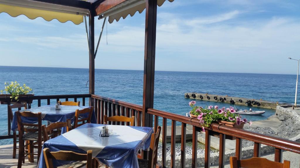 Deux tables sur un balcon avec l'océan en arrière-plan dans l'établissement Tarra, à Agía Rouméli