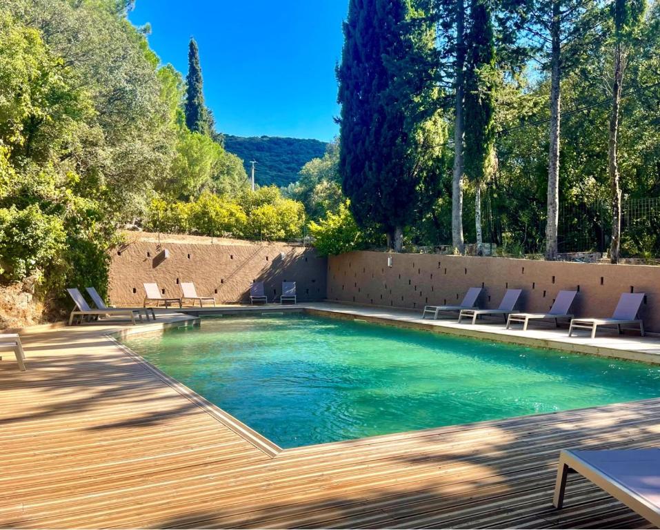 a swimming pool with chairs and a wooden deck at Camping Olva - Maeva in Sartène