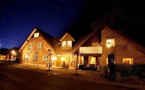 ein großes Backsteinhaus in der Nacht mit Lichtern in der Unterkunft Althoff´s Landhotel in Ochtrup