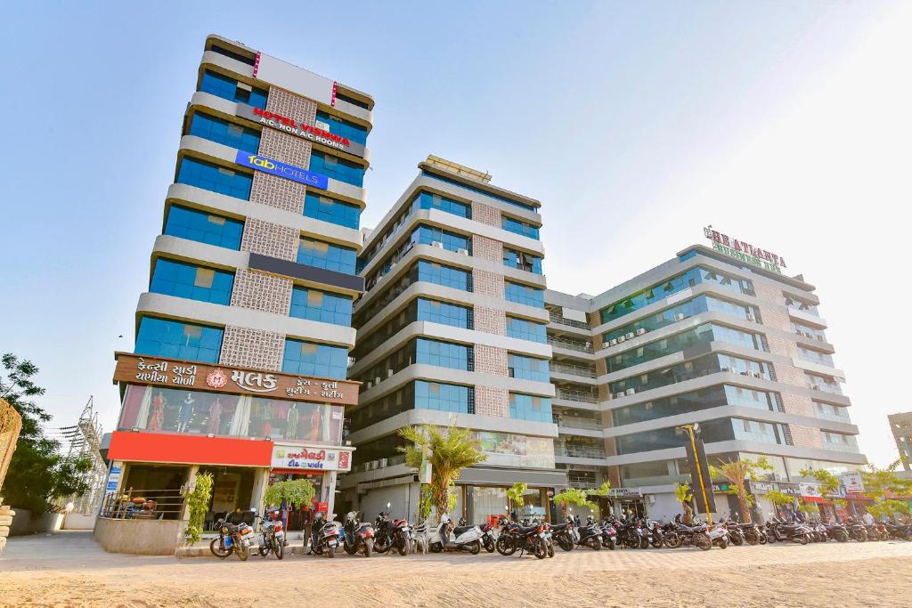 dois edifícios altos com motos estacionadas à frente deles em FabHotel Vishwa em Ahmedabad