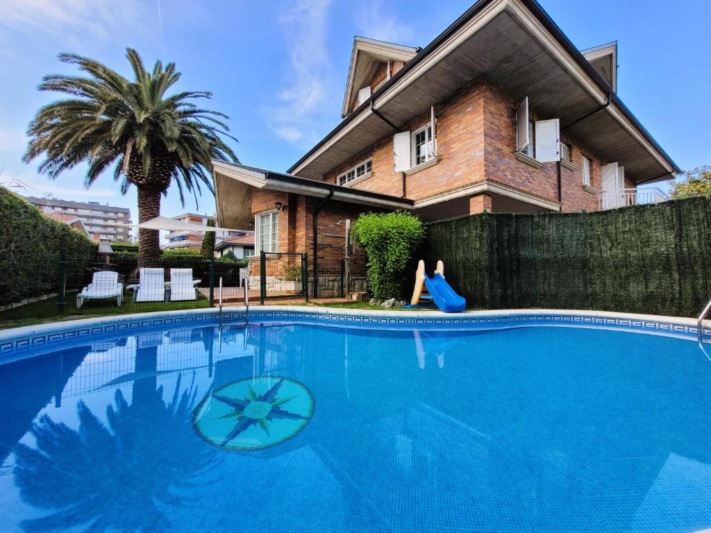 uma casa com piscina em frente a uma casa em Casa Cantábrico em Castro-Urdiales