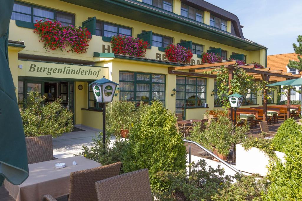a hotel with tables and chairs in front of a building at Burgenländerhof Hotel Garni in Mörbisch am See