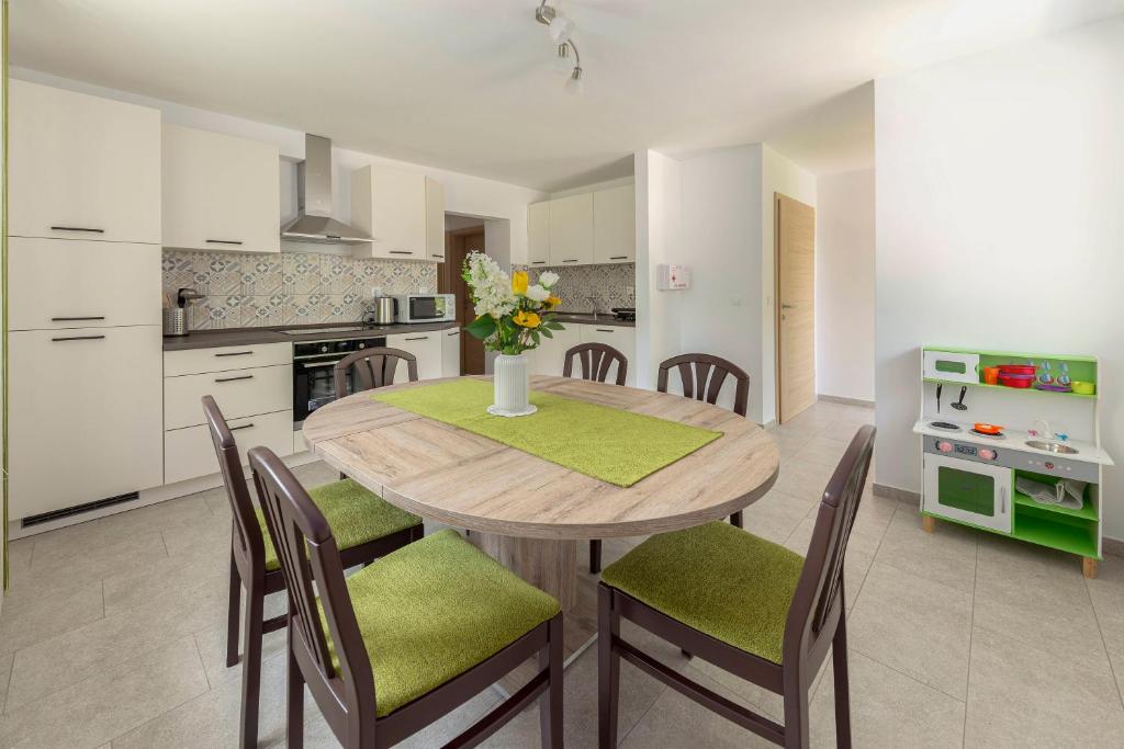 una cucina e una sala da pranzo con tavolo e sedie in legno di Hiša v zelenem a Bled