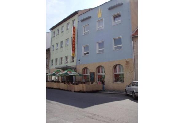 un gran edificio con un coche aparcado delante de él en Hotel Koruna, en Roudnice nad Labem