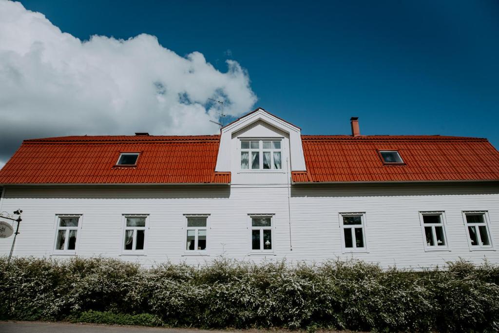 un grande edificio bianco con tetto rosso di Vääksyn Apteekinmajoitus a Vääksy