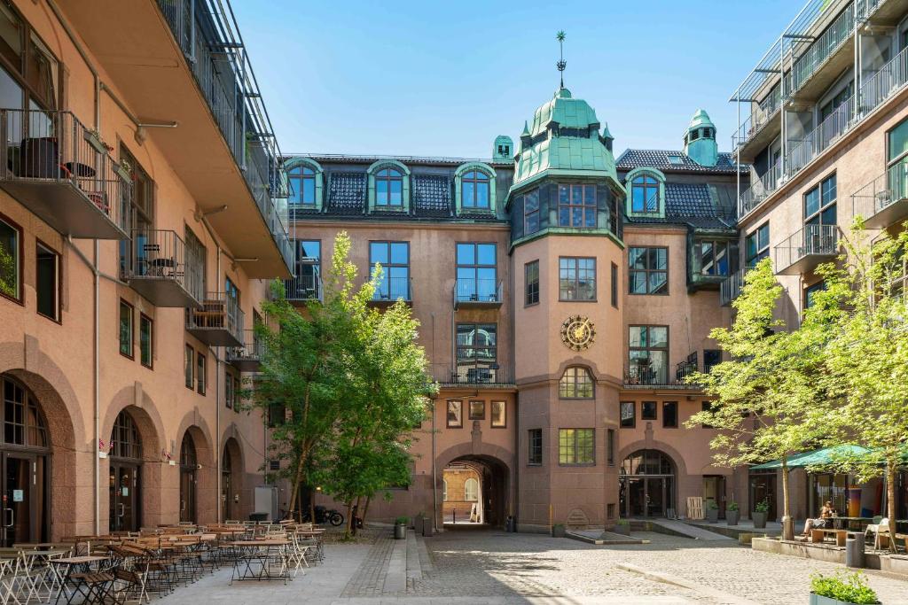 un gran edificio con mesas y sillas en un patio en numa I Hallen Apartments, en Oslo