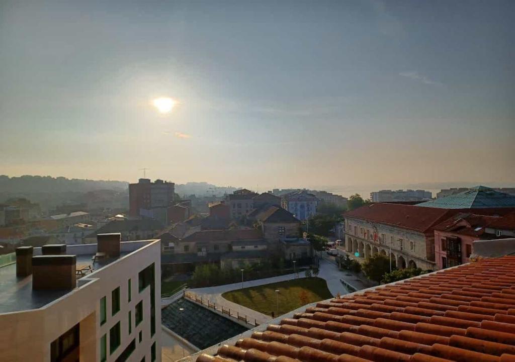 una vista de una ciudad con el sol en el cielo en Habitaciones en El Atico de Tona mirando a la Bahia de Santander, en Santander