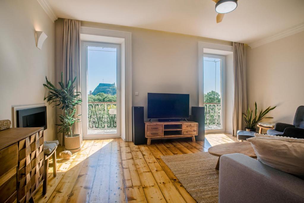 a living room with a flat screen tv and two large windows at Kouketa Luxury in Corfu Town