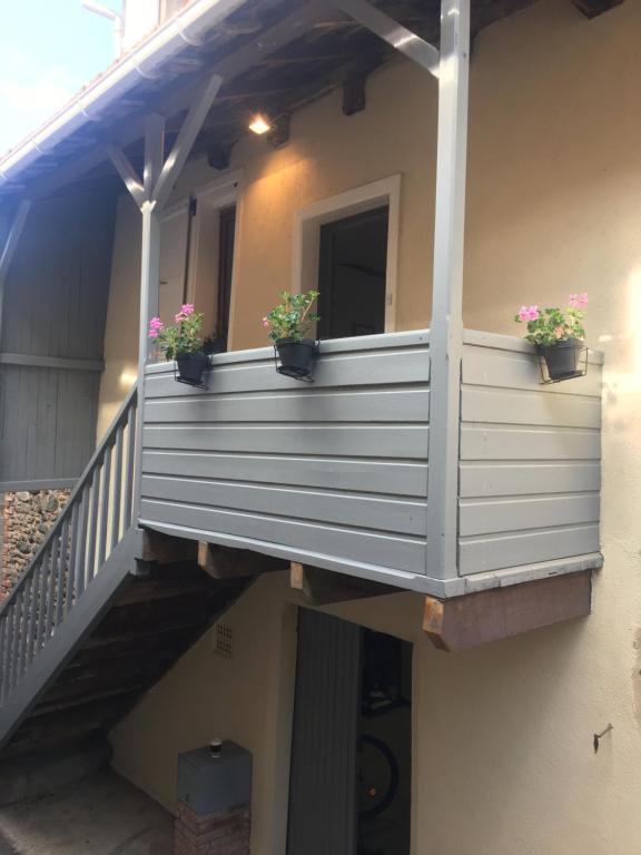 d'un balcon avec des plantes en pot sur une maison. dans l'établissement Mirabel, à Beaulieu-sur-Dordogne