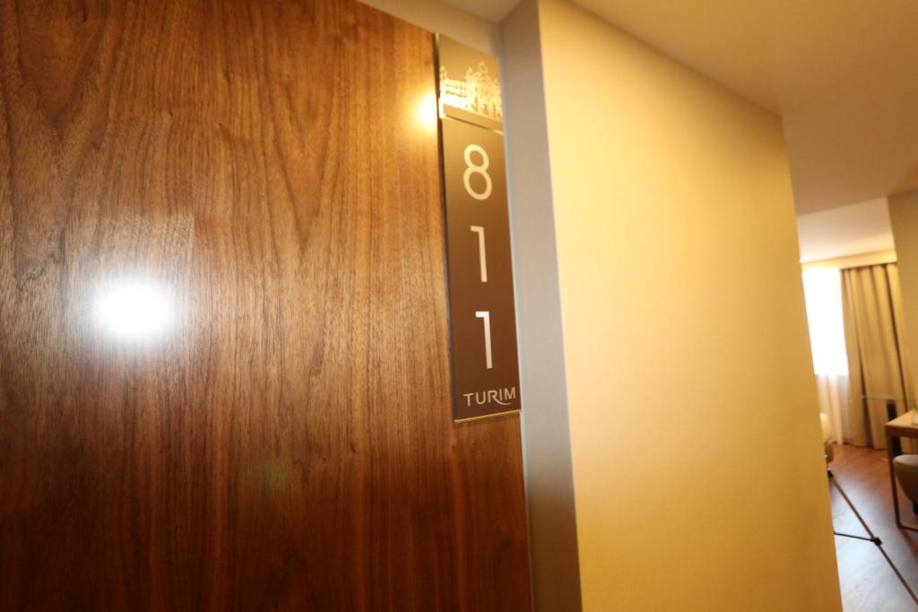 a wooden door with the number eight on it at TURIM Ibéria Hotel in Lisbon