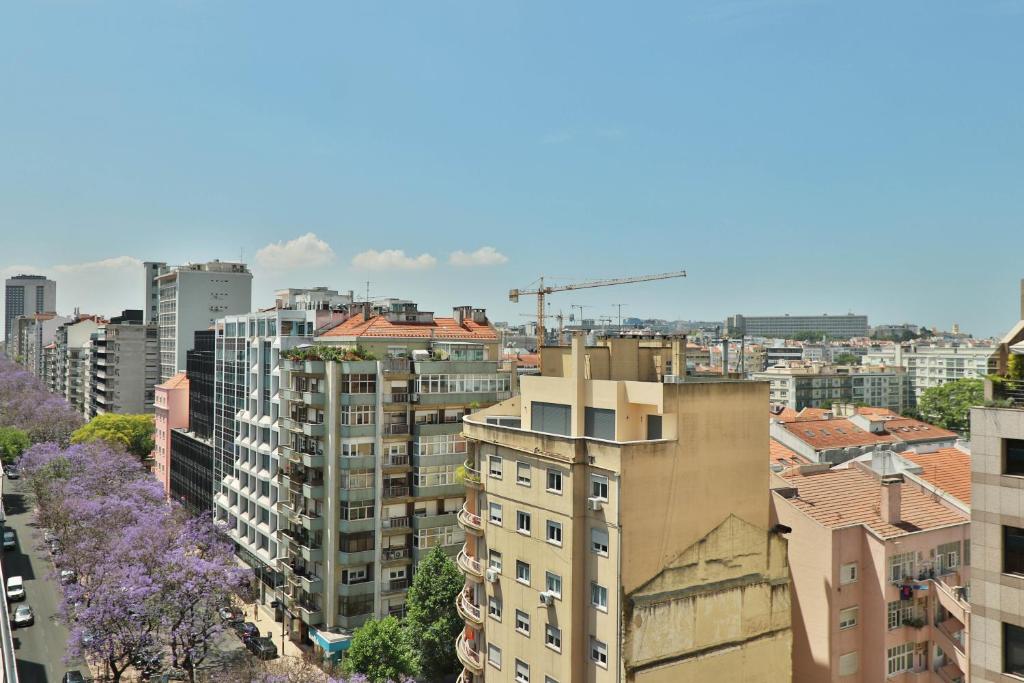 a view of a city with buildings and purple flowers at TURIM Ibéria Hotel in Lisbon