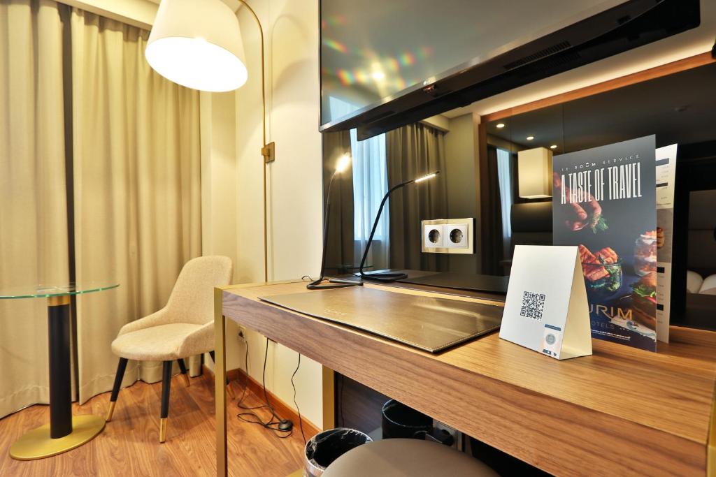 a room with a desk with a laptop and a lamp at TURIM Ibéria Hotel in Lisbon