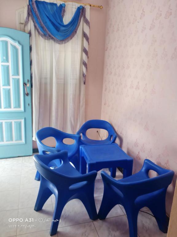 two blue chairs in a room with a window at الوحيد برأس البر in ‘Izbat al Burj
