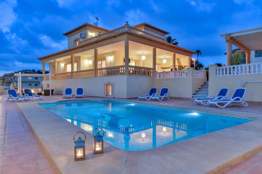 una villa con piscina di fronte a una casa di Villas Guzman - BELLISSIMA a Calpe