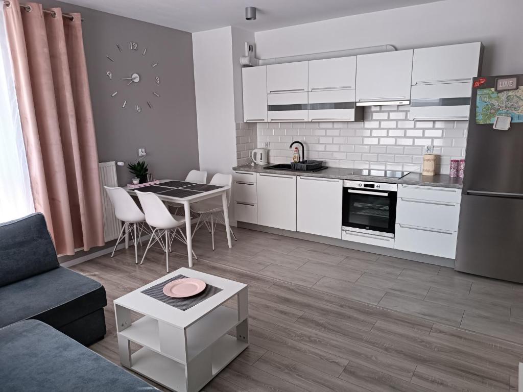 eine Küche und ein Wohnzimmer mit einem Sofa und einem Tisch in der Unterkunft Centrum Haus in Giżycko