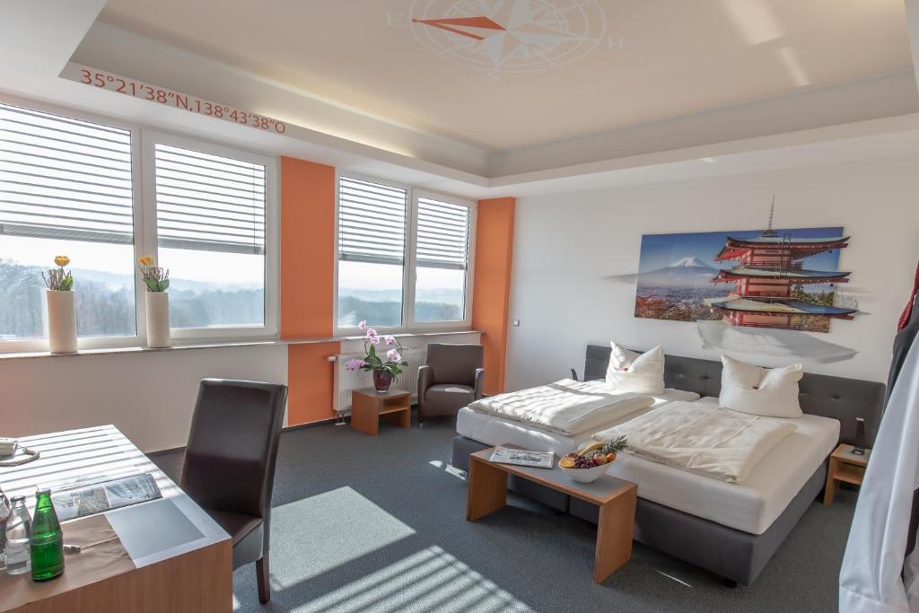 um quarto de hotel com uma cama, uma mesa e cadeiras em Hotel Weitblick Bielefeld em Bielefeld