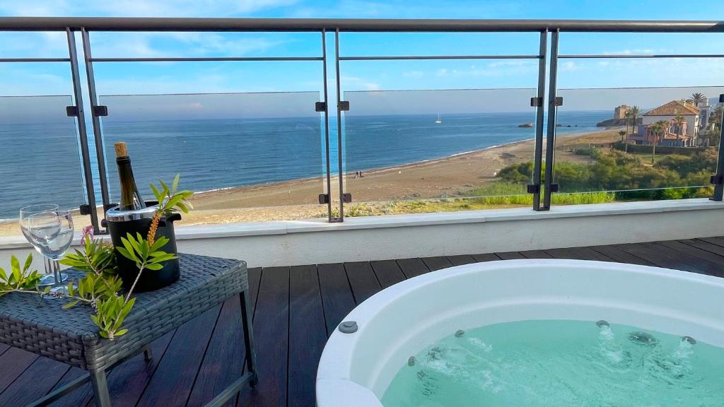 a bath tub with a view of the ocean at Exclusive luxury frontline beach penthouse Casares del mar - Estepona in Casares