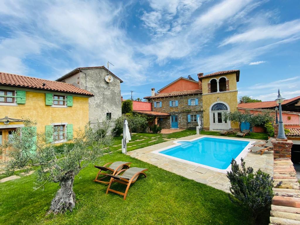 a villa with a swimming pool and a house at Dobrinja Residence Villas Lopar in Marezige