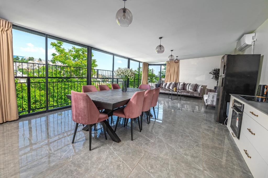 eine Küche und ein Esszimmer mit einem Tisch und Stühlen in der Unterkunft Moses Luxury Vacation Homes-מתחם פיניקס in Safed