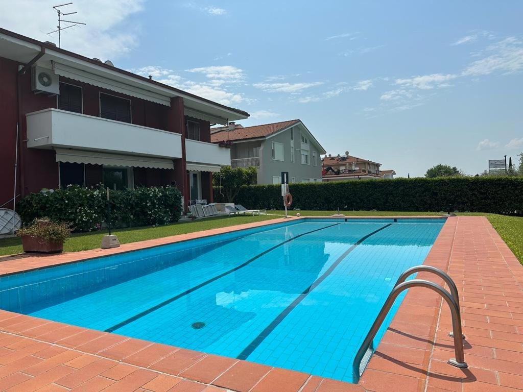 a large swimming pool in front of a house at Bardolino Lake Apartments in Bardolino
