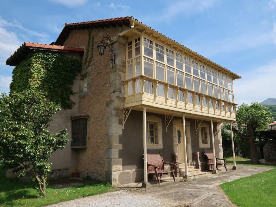 un gran edificio de ladrillo con ventanas laterales. en LA CASONA DE DON ELÍAS en Silió