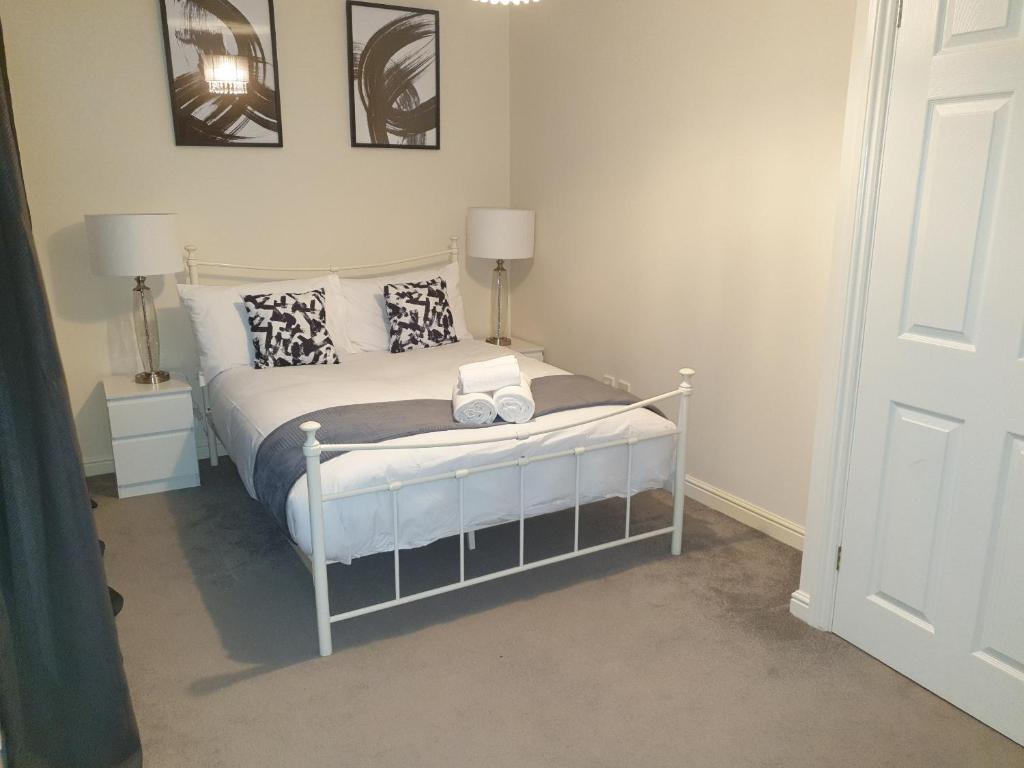 a bedroom with a white bed with pillows at Dreals Apartments in Stevenage