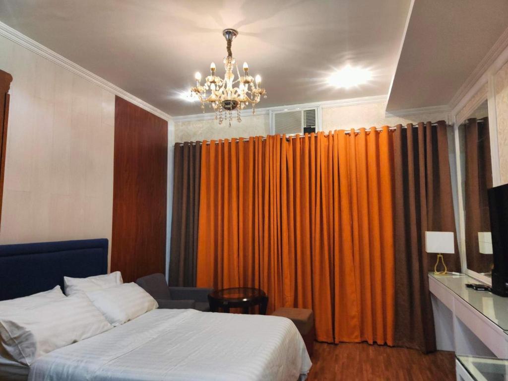 宿霧市的住宿－Trillium Residences Ayala Cebu，一间卧室配有床和橙色窗帘