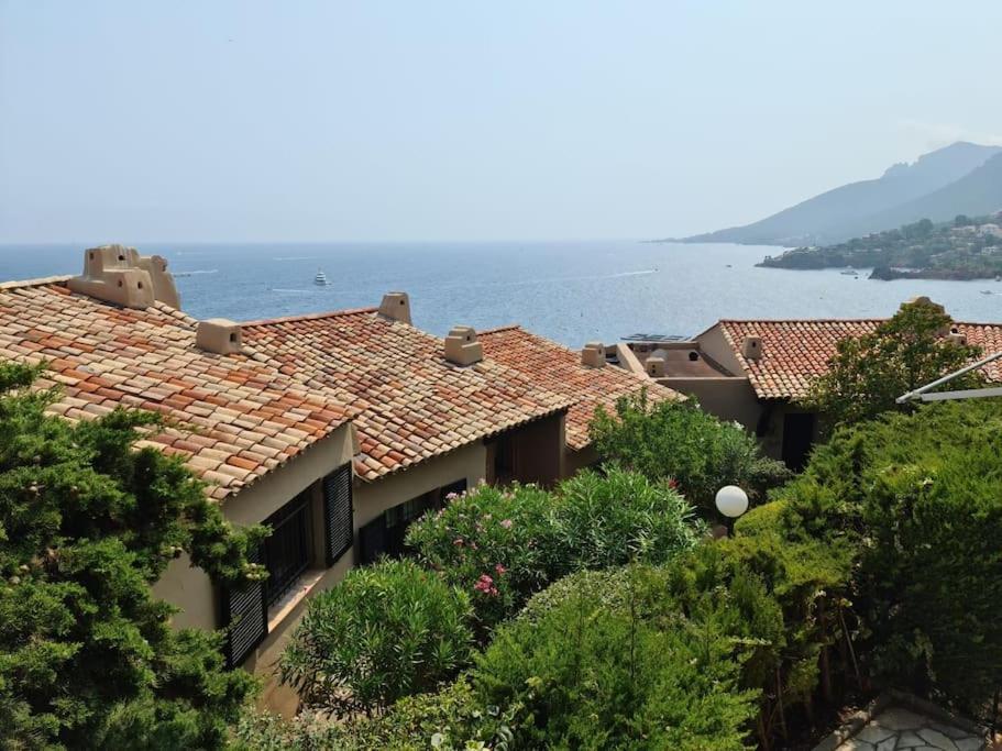 a building with tile roofs and the ocean in the background at Grand studio 35 m2 avec mezzanine et vue mer in Théoule-sur-Mer