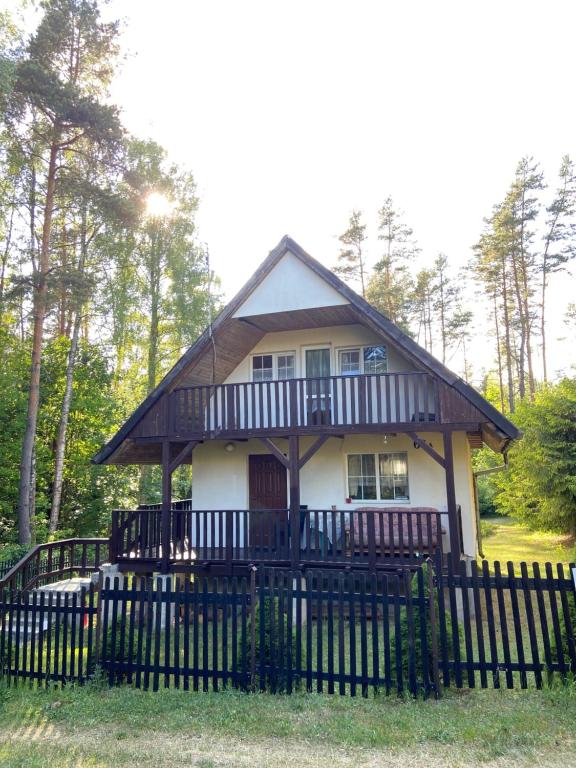 a small house with a black fence in front of it at Aga Kotkowo in Łukta