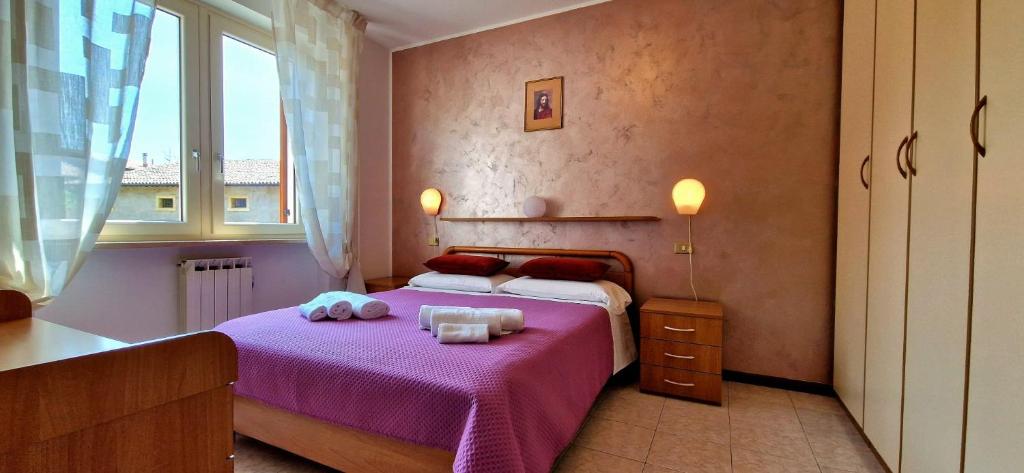 a bedroom with a purple bed with towels on it at Casa Olivo in Negrar
