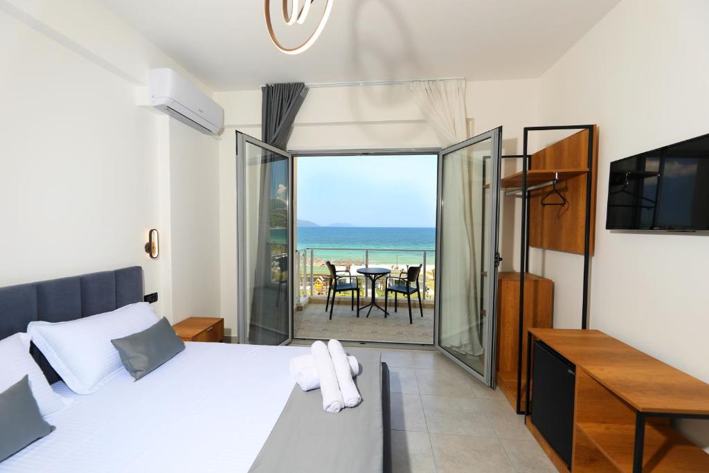 a bedroom with a bed and a view of the ocean at Maor Hotel in Vlorë