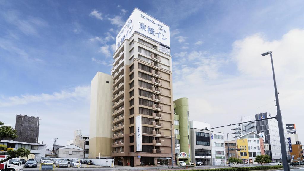 a tall building with a sign on top of it at Toyoko Inn Toyohashi eki Higashi guchi in Toyohashi
