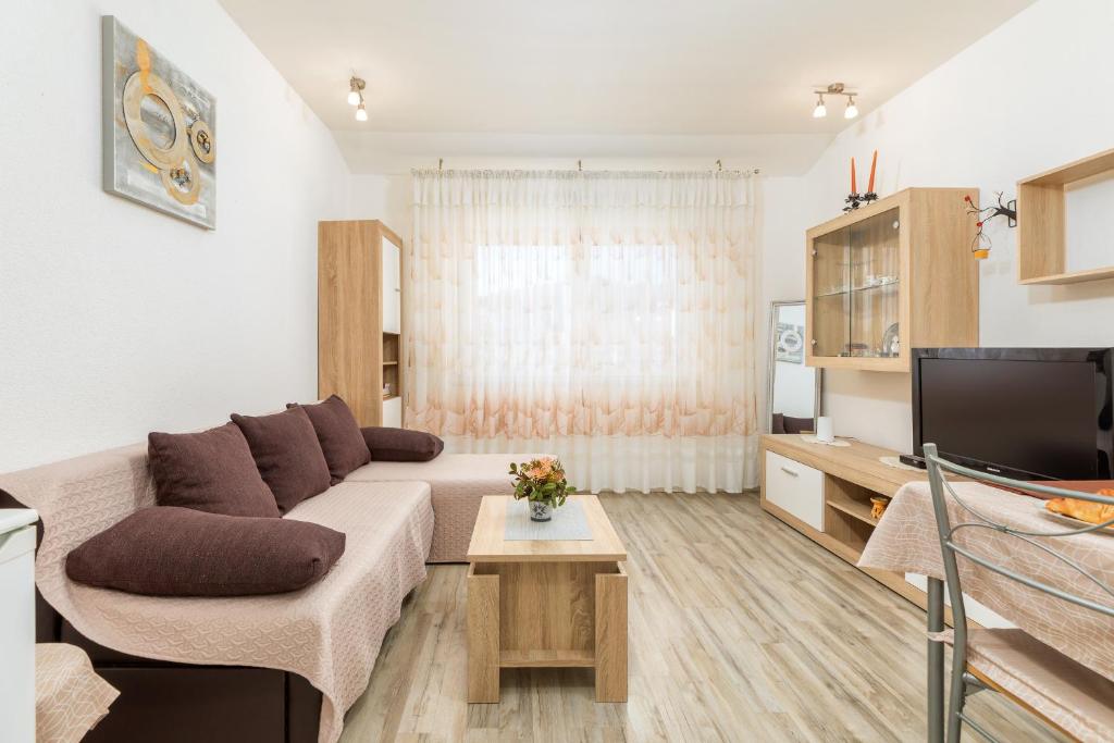 uma sala de estar com um sofá e uma televisão em Relax Apartment Ive em Pula