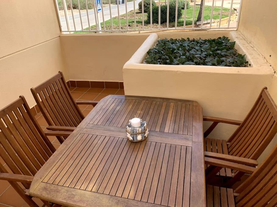 a wooden table with two chairs and a planter with plants at Apartamento dúplex Cabo de Gata in El Cabo de Gata