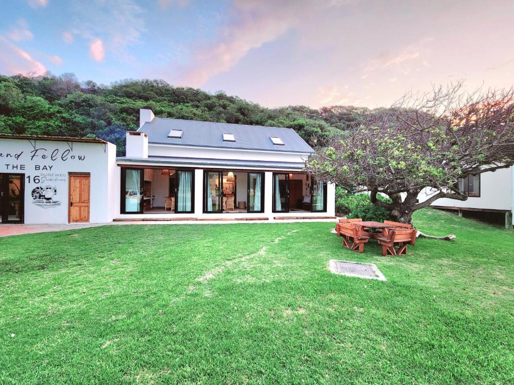 a white building with a tree in the yard at Buff and Fellow by the Bay in Groot Brak Rivier