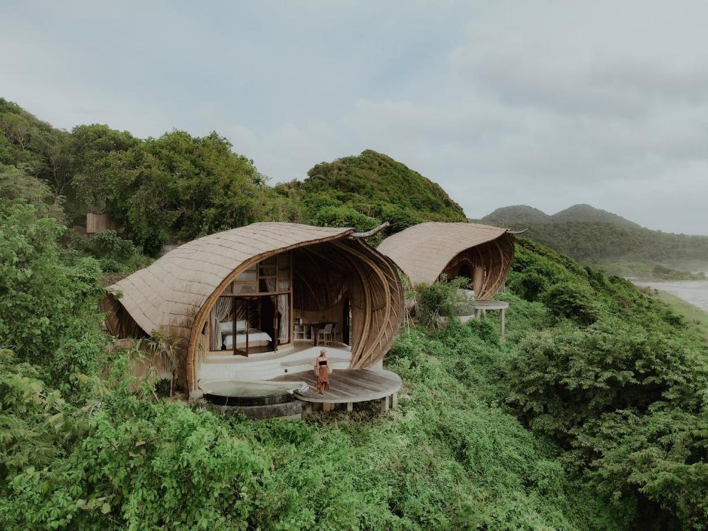 dwie chaty na zboczu wzgórza w obiekcie Kini Resort - Oceanfront Bamboo Eco Lodges w mieście Sekongkang