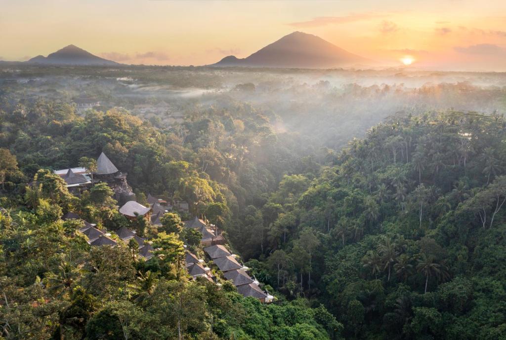 a misty forest with mountains in the background at The Kayon Valley Resort in Ubud