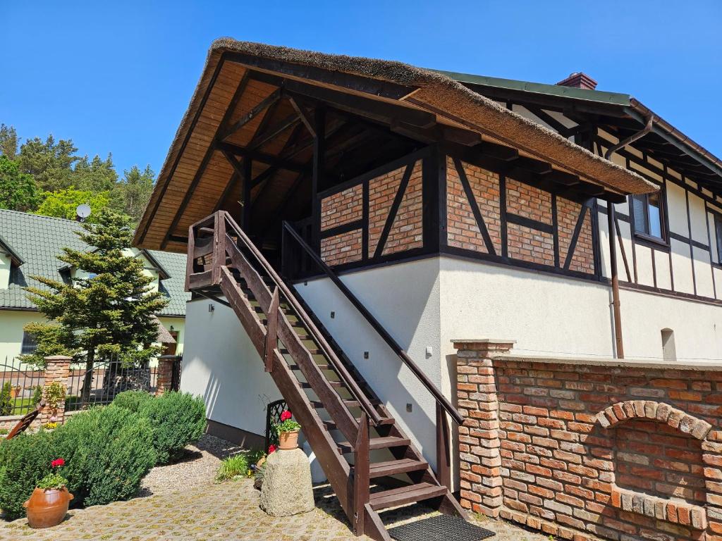 a house with a staircase on the side of it at Nadmorska Strzecha in Smołdziński Las