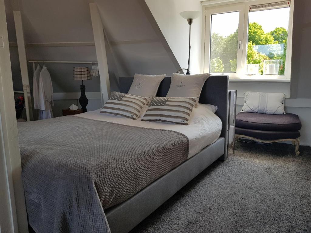 een slaapkamer met een groot bed en een raam bij Deluxe STUDIO-appartement Heemstede Zandvoort in Heemstede