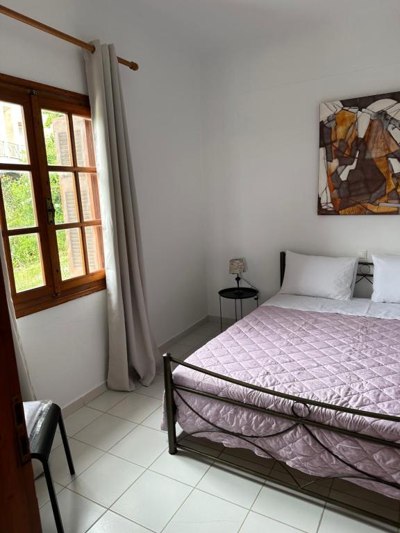 a bedroom with a bed and a window at Flampoura Apartments in Preveza