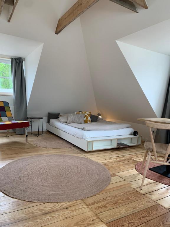 1 dormitorio con cama y alfombra en el suelo de madera en steenkampstudios LOFT, en Hamburgo