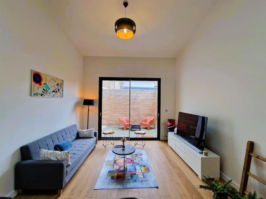 un salon avec un canapé et une télévision dans l'établissement Le Bellay ¤ 2 Chambres ¤ Cour ¤10 mins Centre¤, à Amiens