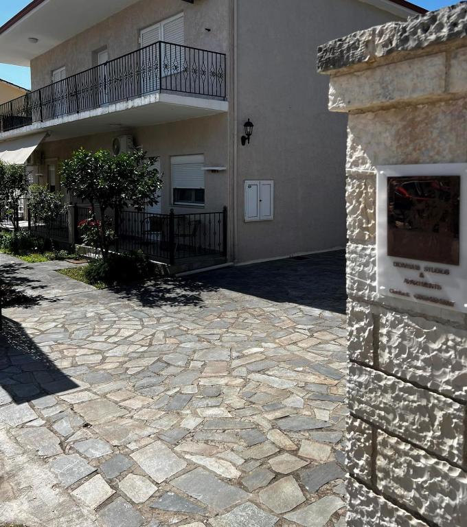 a large house with a stone driveway in front of it at Dionysus Apartments & Studios in Syvota