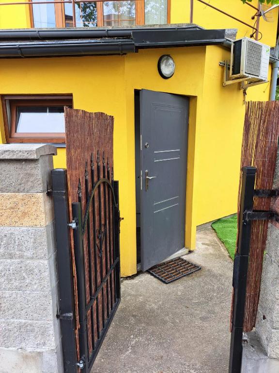una casa gialla con un cancello e una porta di Apartmán pri Sokolovni a Martin
