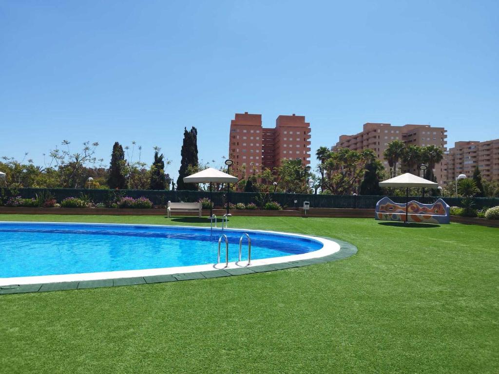 una piscina en un parque con césped y edificios en Costa Caribe III Nº 1108, en Oropesa del Mar