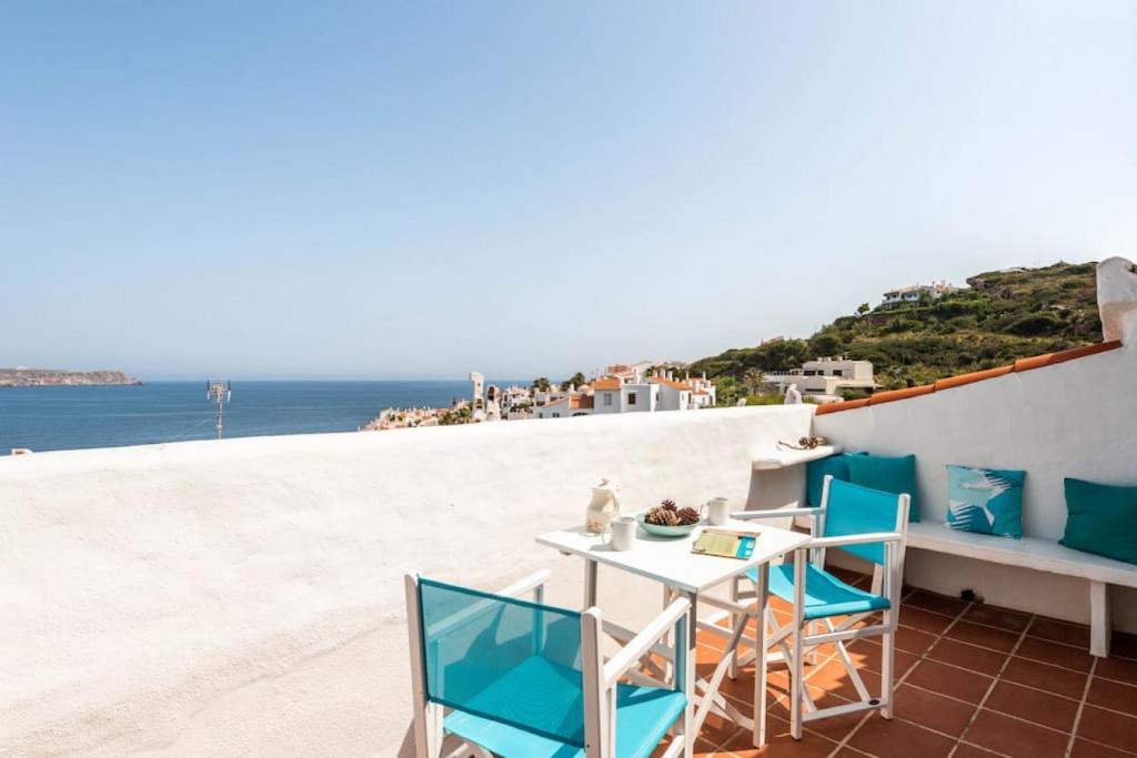 un tavolo e sedie su un balcone con vista sull'oceano di Sunset Tirant a Fornells