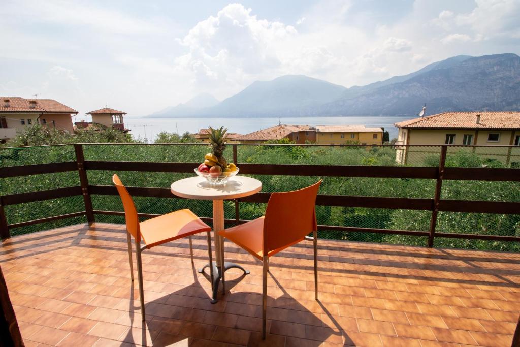 a table and chairs on a balcony with a view at Villa Diana - Appartamenti vista Lago in Brenzone sul Garda