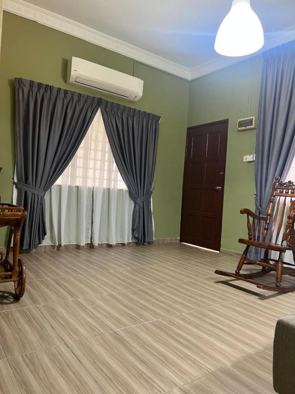 sala de estar con cortinas azules y ventana en Kubu Gajah Homestay, 15 Minutes to Subang Airport, en Sungai Buloh
